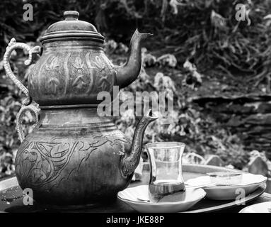 Zwei Vintage gravierte Kupfer türkische Teekannen mit doppelt gestapelt Wasserkocher Tee gebraut, mit einem Glastasse gefüllt mit Tee, so dass im Freien serviert Stockfoto