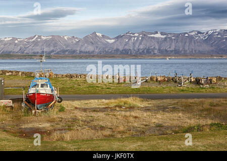 Eine kleine Bootswerft in Dalvik auf einer der nördlichen Halbinseln Islands, mit einer spektakulären Bergkette in der Ferne Stockfoto