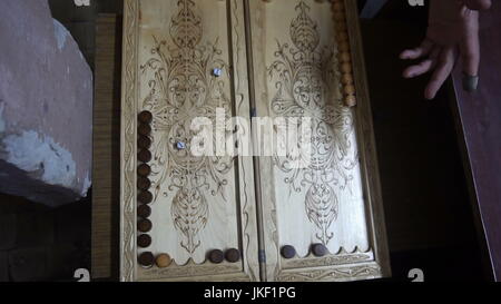 Männer spielen Backgammon, Holzbrett, Rollen Sie die Würfel Stockfoto