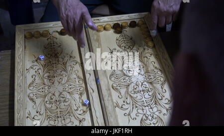 Männer spielen Backgammon, Holzbrett, Rollen Sie die Würfel Stockfoto