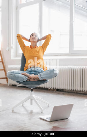 Yung Frau in Ihrer neuen Wohnung sitzen mit einem Laptop Stockfoto