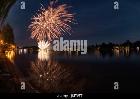 Feuerwerk auf dem Fluss Ticino an einem Sommerabend mit Landschaft im Hintergrund Stockfoto