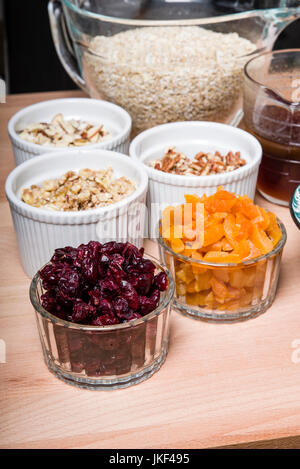 Schalen mit Zutaten für die Herstellung von frischen Müsli mit getrockneten Früchten Stockfoto