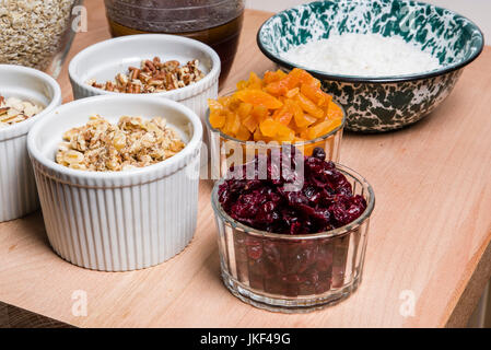 Schalen mit Zutaten für die Herstellung von frischen Müsli mit getrockneten Früchten Stockfoto