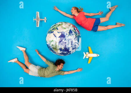 Paar und Flugzeugen rund um den Globus fliegen Stockfoto