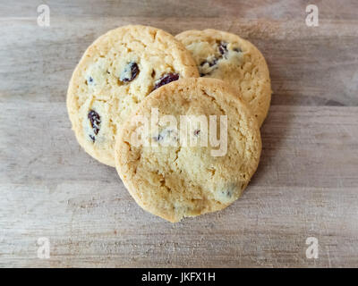 Drei Shorybread mit Rosinen Cookies auf schwarzem Hintergrund isoliert und in der Form eines Herzens positioniert. Stockfoto