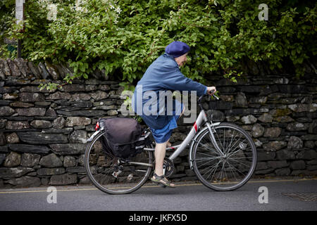 Eine alte Dame durchläuft Grasser Dorf in Cumbria Lake District National Park. Stockfoto