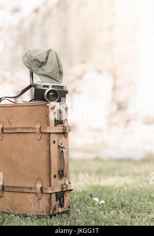 Vintage-Kamera auf alten Gepäck Tasche Gras, alte Tempel-Hintergrund und Vintage-Ton Stockfoto