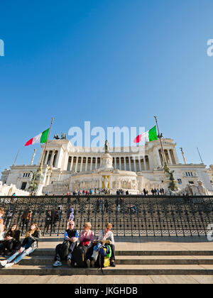Vertikale Perspektive von Menschen sitzen auf den Stufen vor dem Vittoriano oder Victor Emanuele II Denkmal in Rom. Stockfoto