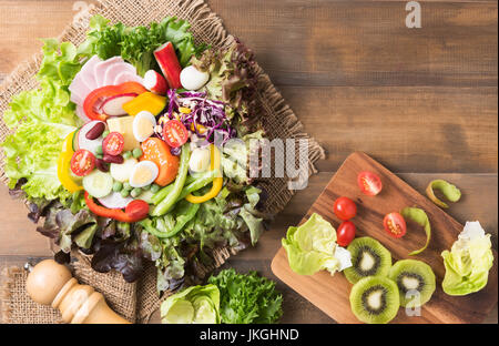 frische Mischung Vegetation Salat auf braunem Holz Hintergrund, Konzept-Diät und gesunde Ernährung Stockfoto