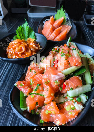 Japanisches Essen Lachs Tataki (würzige Lachssalat) mit Lachs-Sashimi (roher Lachs Frischfleisch) und hotate Kimuchi (scharfe gekochte Jakobsmuschel mit Kimchi Sau Stockfoto