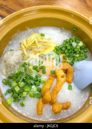Reisbrei, Reisbrei, Reis Brei, Conjee oder Reis-Suppe mit Ingwer, Frühlingszwiebeln und kleine Krapfen-wie Pathongko oder Tiefe frittierten Teig Stick gekrönt. Asien Stockfoto