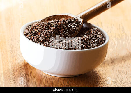 Chia-Samen in einem Holzlöffel auf einer weißen Schüssel Stockfoto