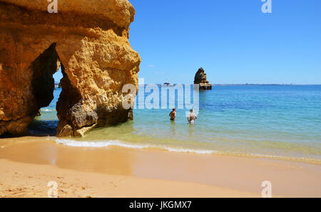 Berühmte Lücke zwischen Felsen an Camilo Strand (Praia Do Camilo) an der Algarve, Portugal mit türkisfarbenen Meer im Hintergrund Stockfoto