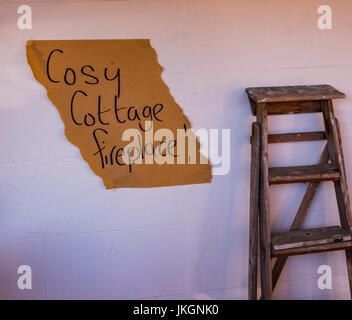Maler Leiter stehend gegen eine weiße Wand vor einem Café "Cosy Cottage Kamin" in Hahndorf, South Australia Stockfoto