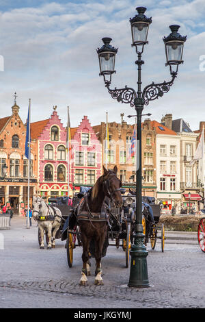 Pferdekutschen auf dem Grote Markt Platz in der mittelalterlichen Stadt Brügge am Morgen, Belgien. Stockfoto