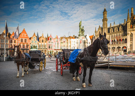 Pferdekutschen auf dem Grote Markt Platz in der mittelalterlichen Stadt Brügge am Morgen, Belgien. Stockfoto