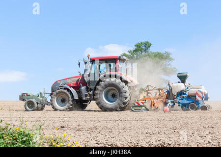 Landwirt Bohr- und Bepflanzung der Frühling-Ernte von Mais in einen Acker mit ein Valtra-Traktor und Monosem NG plus 4 pneumatische Reihe fünf Pflanzer Stockfoto