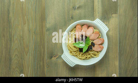 Spaghetti mit Wurst und getrocknete Paprika, würzig und scharf auf hölzernen Hintergrund, Ansicht von oben Stockfoto