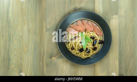 Spaghetti mit Wurst und getrocknete Paprika, würzig und scharf auf hölzernen Hintergrund, Ansicht von oben Stockfoto