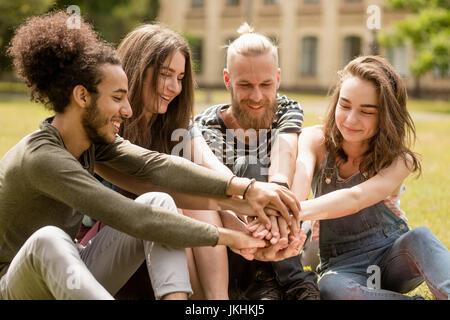 Junge glückliche Schüler Spaß haben, sitzen im Park. Stockfoto