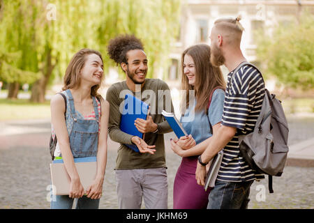 Multiethnische Gruppe von Studenten, die angeregte Unterhaltung auf dem Campus. Stockfoto