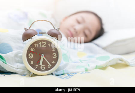 Wecker auf 06:00 und Girl Schlaf Hintergrund Stockfoto