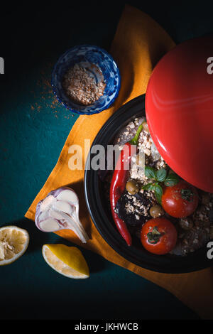 Tazhin mit Tilapia und Gemüse auf Tischdecken vertikale Stockfoto