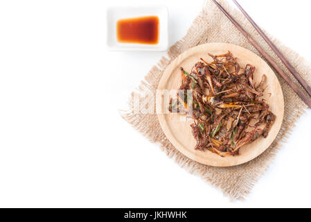 Gebratene Heuschrecken isoliert auf weißem Hintergrund auf Draufsicht mit Textfreiraum, lokales Essen in Thailand Stockfoto