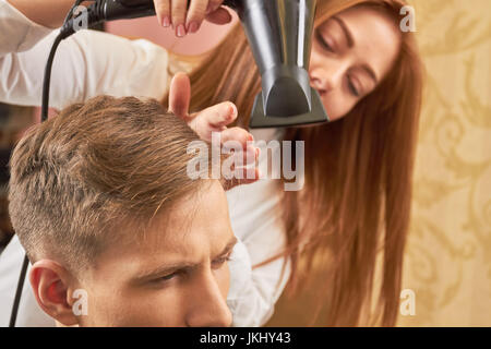 Barbier trocknen Haare des Clients. Stockfoto