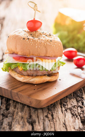 Hamburger, hausgemachte Hamburger mit frischem Gemüse auf alten Holz Hintergrund Stockfoto