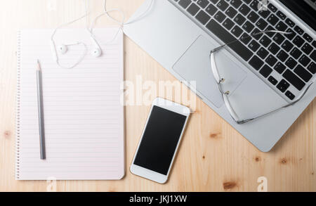leere Arbeitsmappe mit Smartphone und Laptop am Schreibtisch aus Holz Stockfoto