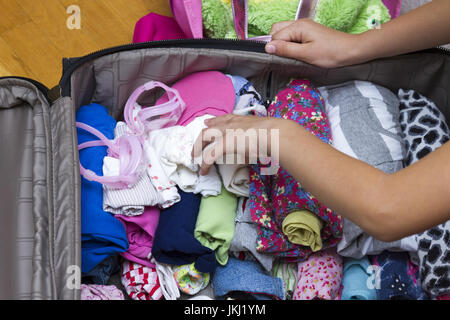 In der Nähe von Frau packen Kleidung in Reisetasche - Gepäck und Menschen Konzept Stockfoto