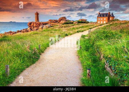 Atemberaubenden Sonnenuntergang mit Leuchtturm von Ploumanach bedeuten Ruz in Perros-Guirec auf rosa Granit Küste, Bretagne, Frankreich, Europa Stockfoto