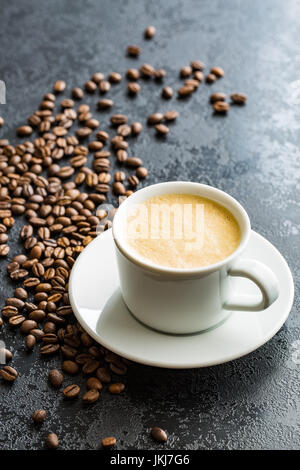 Heißen Kaffee Cappuccino und Kaffee Bohnen auf schwarzen Tisch. Stockfoto