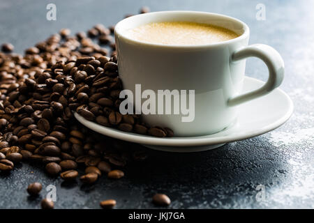 Heißen Kaffee Cappuccino und Kaffee Bohnen auf schwarzen Tisch. Stockfoto