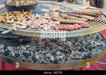 Großes Barbecue-Grill. Rippen, Chorizo und Hähnchen. Kochen im Freien. Traditionelles Essen von Spanien. Mittelalterlicher Markt. Rohes und gekochtes Fleisch. Warmton. Stockfoto