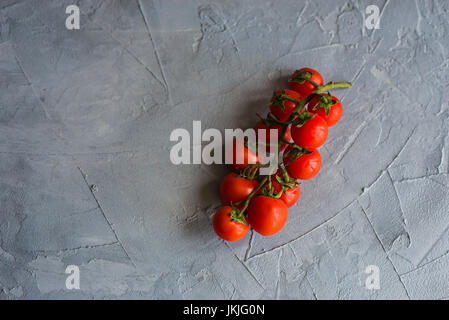 Bio-Tomaten auf grauem Beton Hintergrund Stockfoto