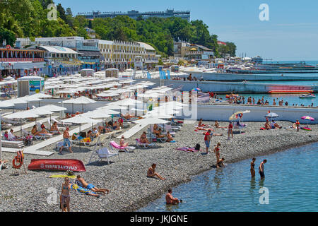 Sochi, Russland - 06. Juli 2017. die Leute Schwimmen und Sonnenbaden am Strand der Stadt Sotschi. Strand mit Touristen, Sonnenliegen und Sonnenschirmen Stockfoto