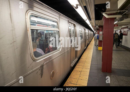 Zug am Bahnsteig in u-Bahn Station Zeichen 34th Street Penn Station New York City USA Stockfoto