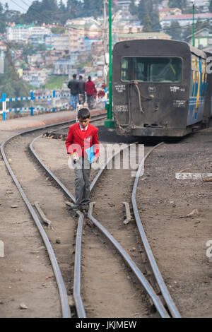 DARJEELING, Indien - 28. November 2016: Die Darjeeling-Bahn haben Eisenbahn in der Nähe von Straße und Menschen wegen dieser Stadt befindet sich auf hohe Haltung Platz. Stockfoto