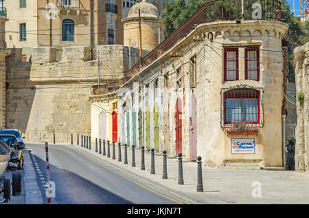 Valletta, Malta - 4. Juni 2017: Eine typische schmale Straße mit der alten Gebäude aus Kalkstein mit Colorfull Tore und Stadtmauern Hl.Barbara Bastion in Stockfoto