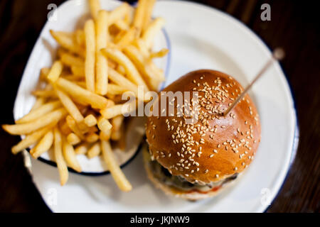 Doppel-Cheeseburger und Pommes Frites auf rustikale weiße Weissblech Stockfoto