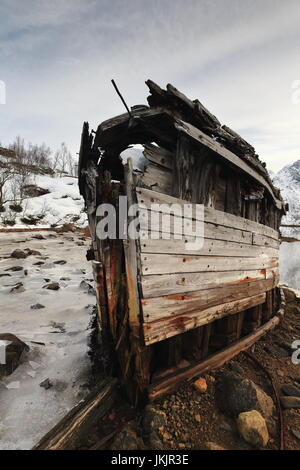 Schiffbrüchige Holzboot gestrandet-Sildpolltjonna Bucht unten-S.shore Sildpollnes Halbinsel-Austnesfjorden. Langstrandtindan Gebirgshintergrund. Vagan k Stockfoto