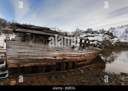 Schiffbrüchige Holzboot auf Grund Sildpolltjonna Bucht unten-S.shore Sildpollnes Halbinsel-Austnesfjorden. Langodden Landzunge-Stortinden mt.on zurück. Vaga Stockfoto