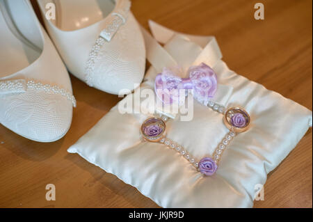 Weiße Braut Schuhe und Trauringe auf Holzboden Stockfoto