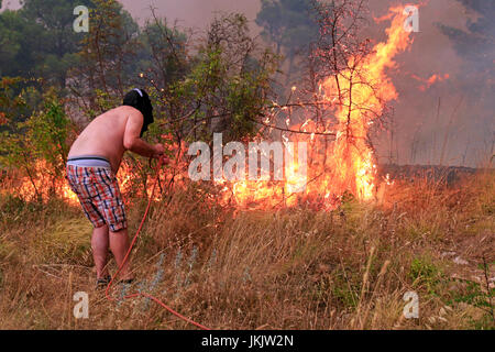 Zrnovnica, Split, Kroatien - 17. Juli 2017: Mann im Kampf mit den massiven Lauffeuer brennen die Wälder und Dörfer in der Umgebung der Stadt Split Stockfoto