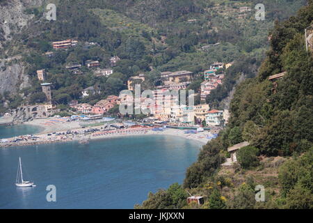 Landschaft Blick auf eines der fünf Dörfer entlang der klaren, blauen Meer während einer Wanderung von einem Dorf zum anderen in den Cinque Terre, Italien Stockfoto