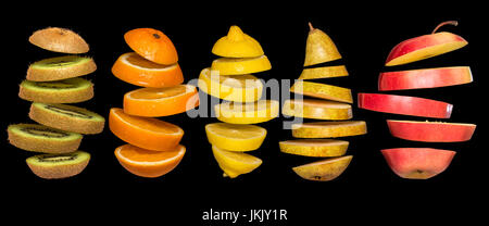 Kreatives Konzept mit Lebensmitteln. Satz von geschnittenem Obst auf schwarzem Hintergrund isoliert. Fliegen, Zitrone, Orange, Kiwi, Birne, Apfel. Leichtsinn Obst schwebend, in der ein Stockfoto