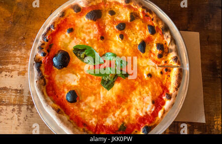 Pizza Margharita, eine klassische neapolitanische Pizza mit Mozzarella, Tomaten und Basilikum, erstellen die Farben der italienischen Flagge: rot, weiß und grün Stockfoto
